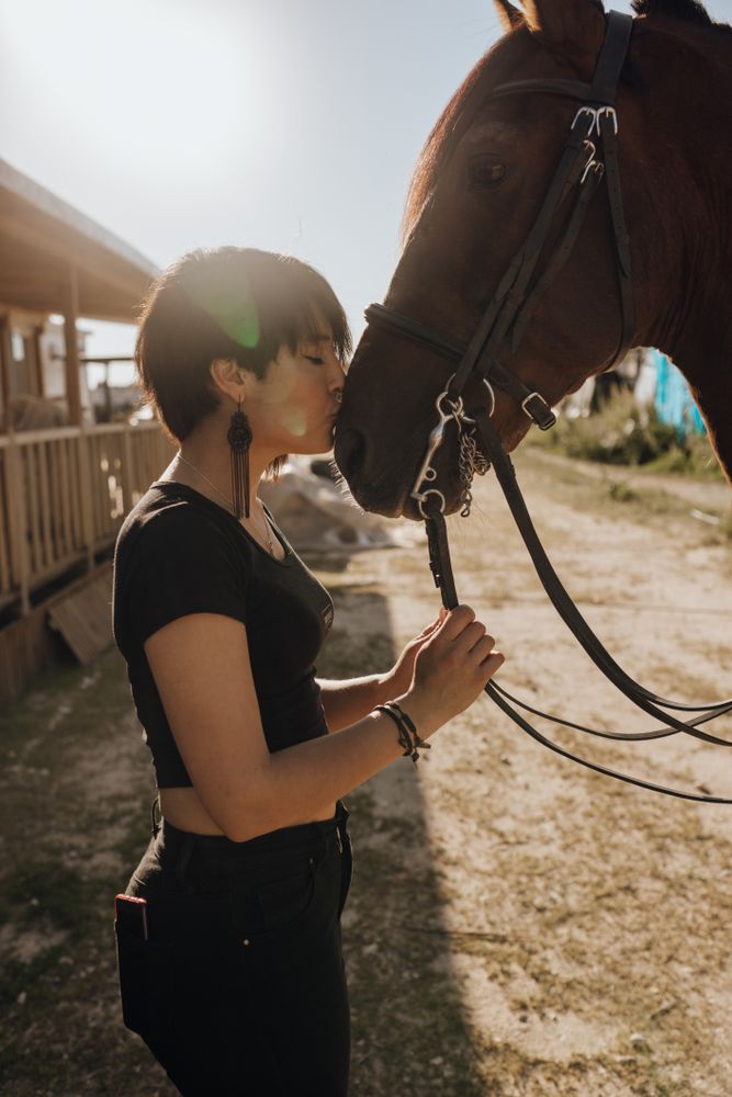 Woman kissing horse on ranch