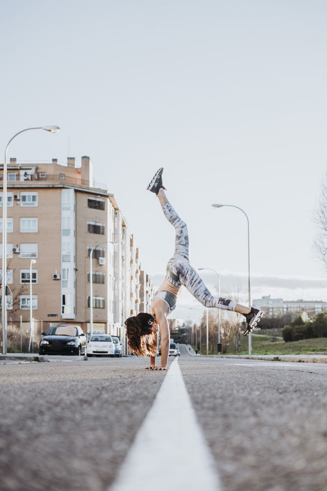 Woman doing handstand on street