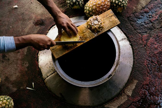 Casual man cutting pineapple