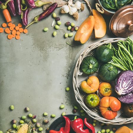 Seasonal fall vegetables in baskets and plates on concrete background, copy space, square crop