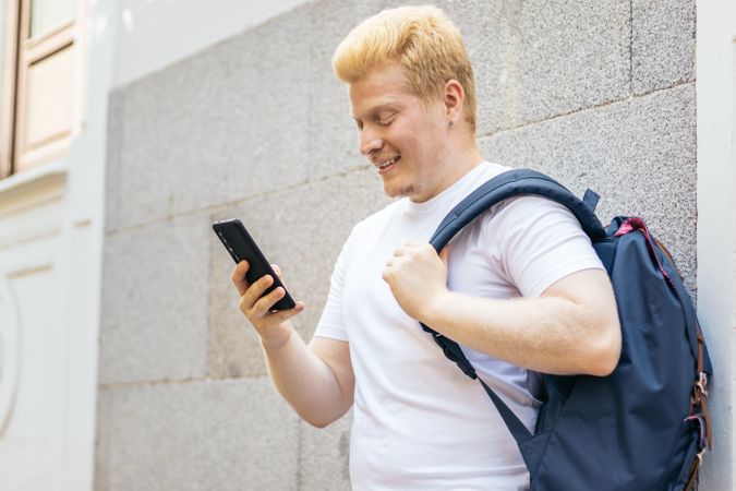 Latino man with albinism using smartphone in the city