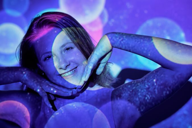 Cheerful female under vibrant sparkles