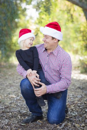 Portrait of Father and Daughter Wearing Santa Hats