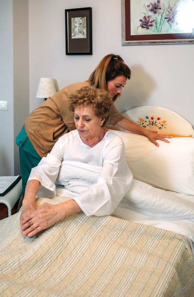 Caregiver accommodating pillow to older patient