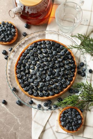 Concept of tasty lunch with blueberry pie on gray table