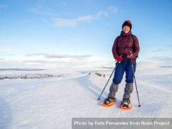 Smiling woman in snow shoes on wintry landscape 42DD30