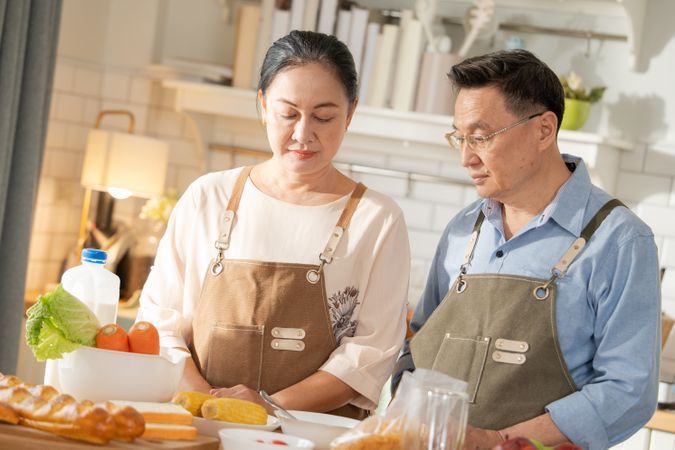 Asian couple cooking breakfast in the kitchen