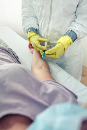 Unrecognizable female doctor injecting vaccine to patient