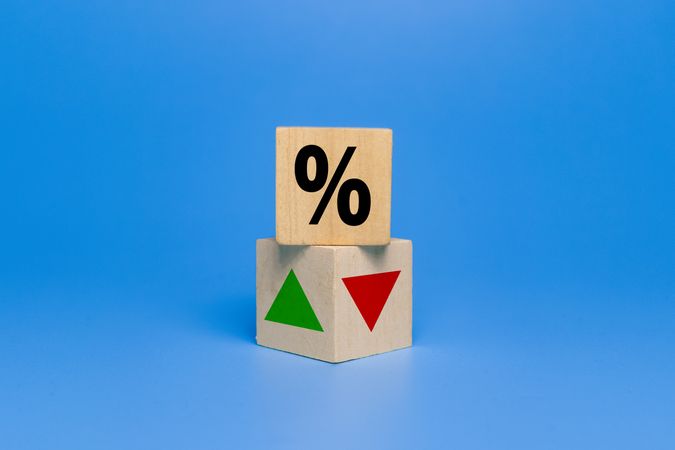 percentage symbol with up and down arrow on wooden isolated on blue background. concept of interest rate financial and mortgage rate growth