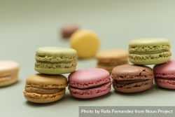 Pile of pastel colored macaroons over a green background 56GlQN