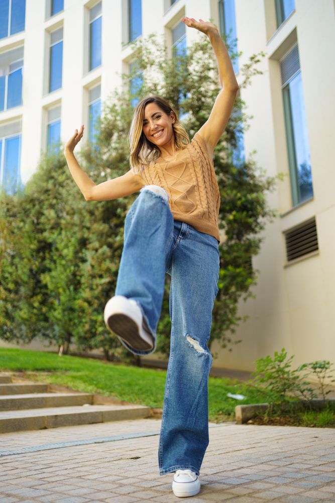 Stylish woman dancing on street