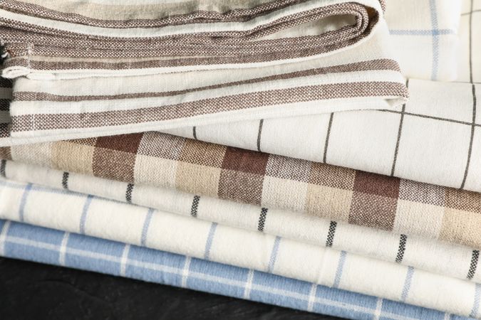Stack of fabric napkins on dark table, close up