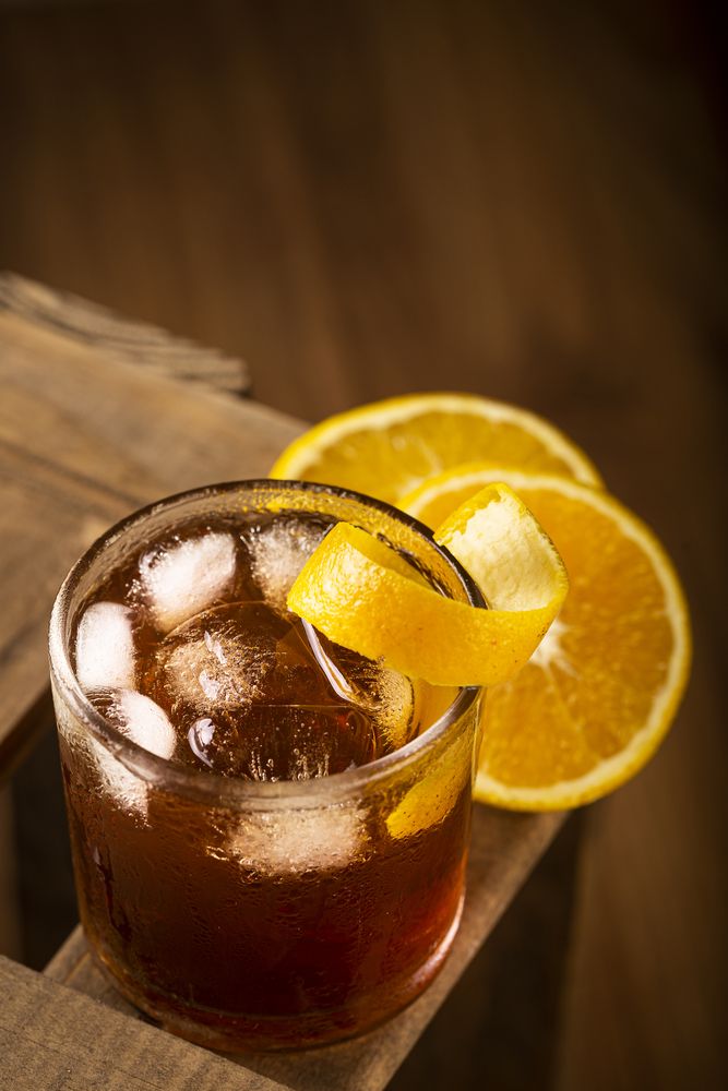 Negroni cocktail with orange, on wooden background.
