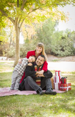 Family Enjoying Christmas Gifts in the Park Together