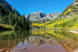 Rocky Mountain peaks with bright yellow wildflowers and lake z0gjXb