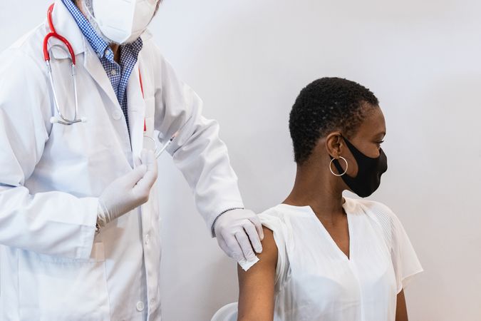 Doctor making injection for Black woman patient
