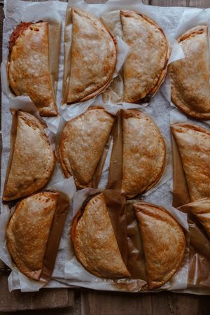 Baking tray with composed freshly baked pies patty