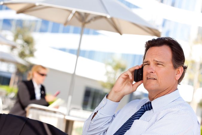 Businessman Smiles as He Talks on His Cell Phone