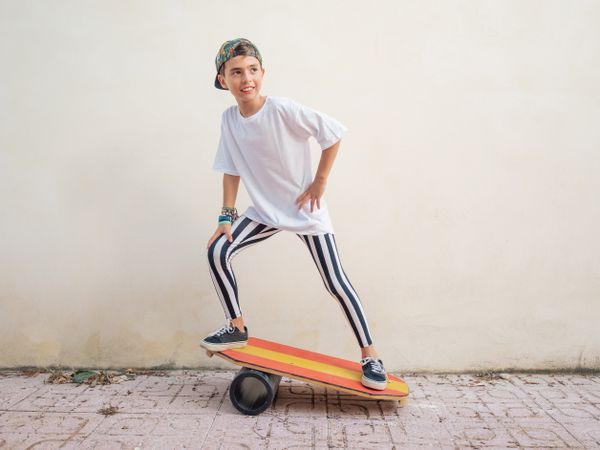 Cheeky boy standing on colorful board and swinging
