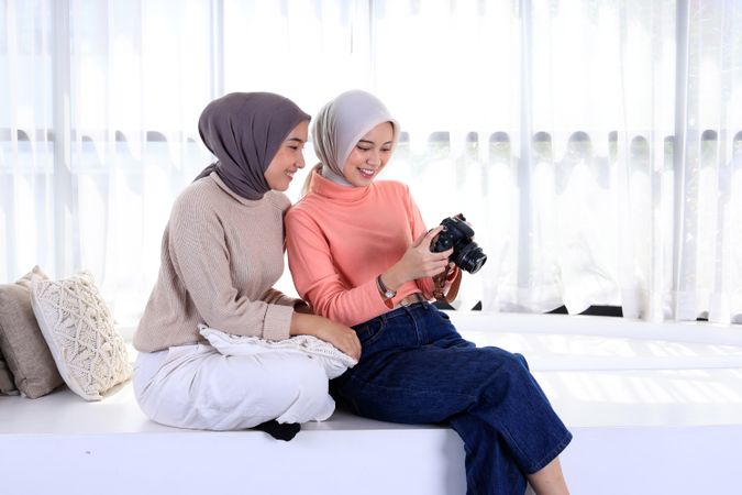 Two Young Asian Muslim Women in Beautiful Hijab Holding the Camera and Looking into it.