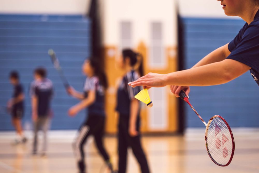 Teenage girls playing tennis at school