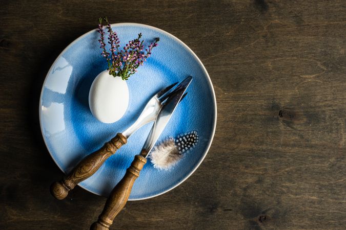 Top view of heather in decorative egg on blue plate