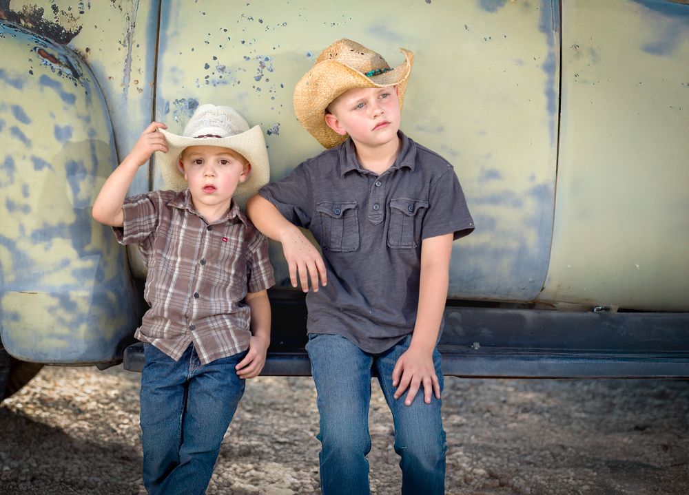 Two Young Boys Wearing Cowboy Hats Leaning Against Antique Truck.