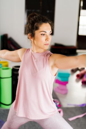 Brunette in comfortable sportswear while practicing yoga in studio