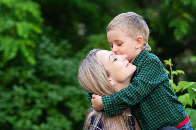 Portrait of young mother spending time with son in backyard