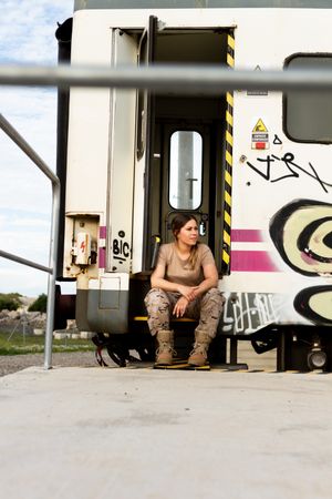 Military woman sitting near van