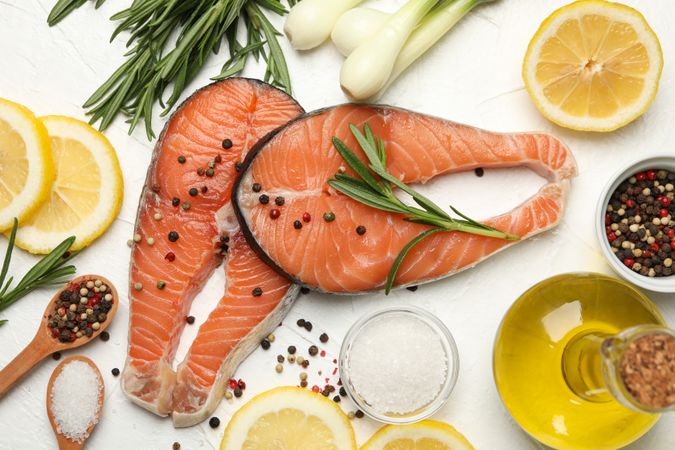 Composition with salmon meat and spices light background, top view