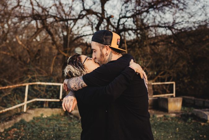 Young couple hugging and kissing in forest
