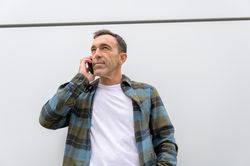 Thoughtful man talking on smartphone