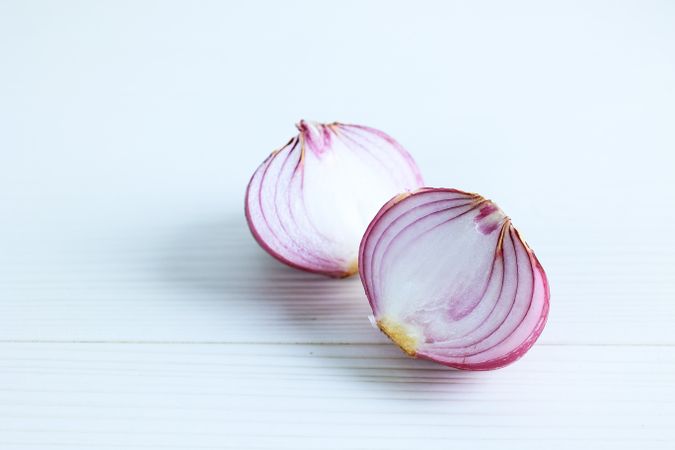 Peeled and Halved Red Onion on a Wood Table: Two Pieces of Peeled Purple Onion