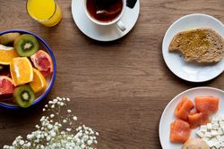Juice and plate with granola and fruits on table
