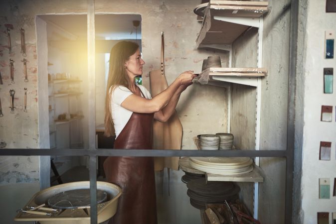 Woman in leather apron working in ceramics studio