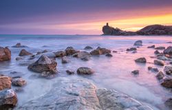 Sundown sky over sea and stony coast