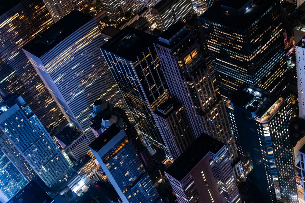 New York City Aerial Night Cityscape with Stunning Manhattan Landmarks, Skyscrapers and Residential Buildings. Helicopter Down View of the Urban Architecture