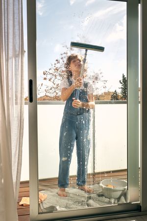 Child washing windows at home