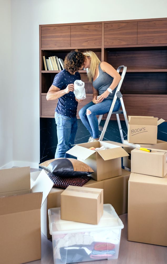 Couple kissing while unpacking boxes
