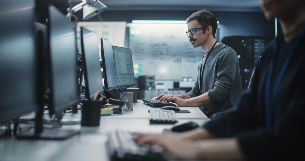Portrait of a Thoughtful Engineer Working on Desktop Computer in a Technological Office Environment.