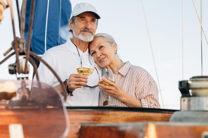 Happy older couple relaxing with wine on a boat