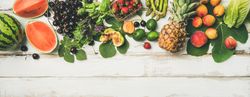 Summer fruits of pineapple, cherries, figs, strawberry on wood, wide composition, copy space