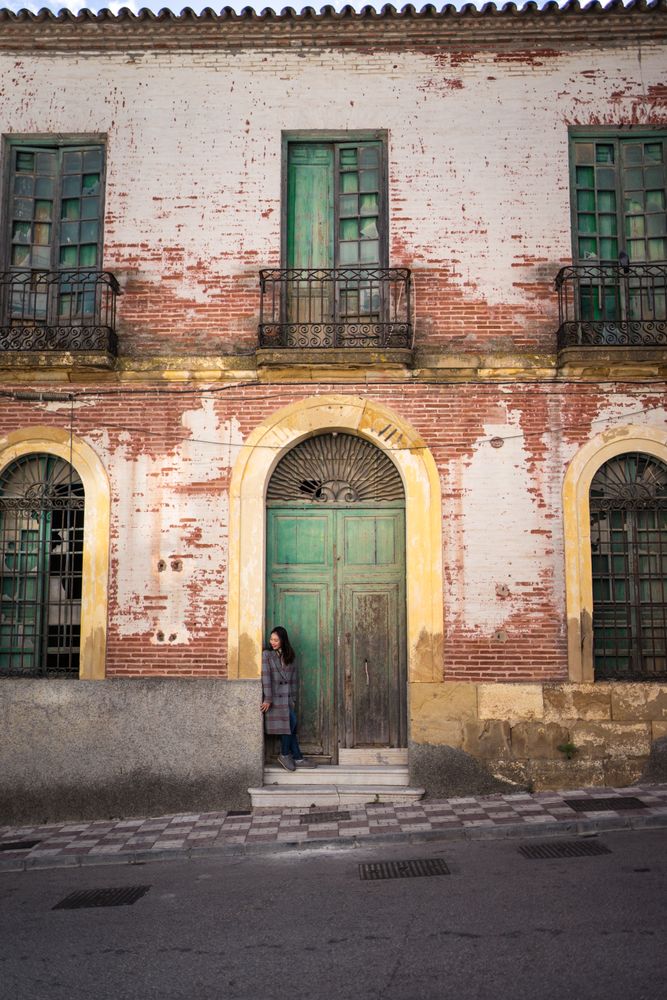 Woman on street with aged building