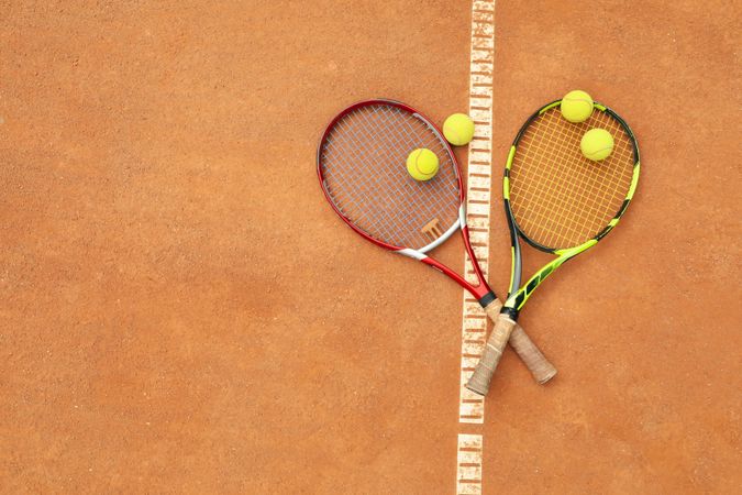 Tennis racquets with tennis balls on clay court