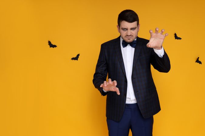Concept of Halloween, young man on yellow background