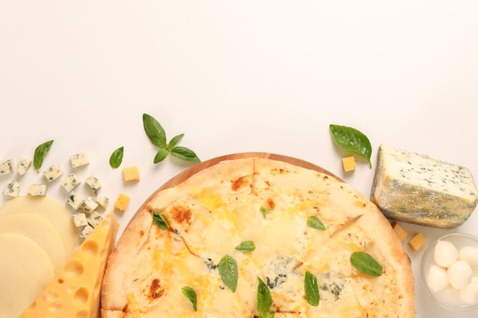 Flat lay. Cheese pizza and ingredients on plain background, copy space