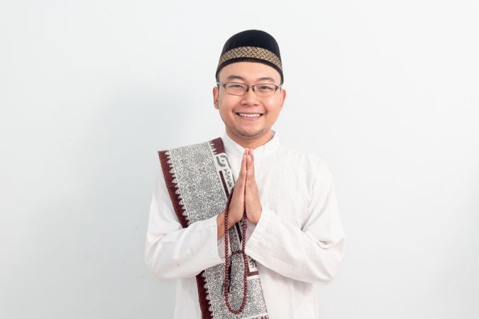 Asian Muslim man smiling doing greeting pose during Ramadan