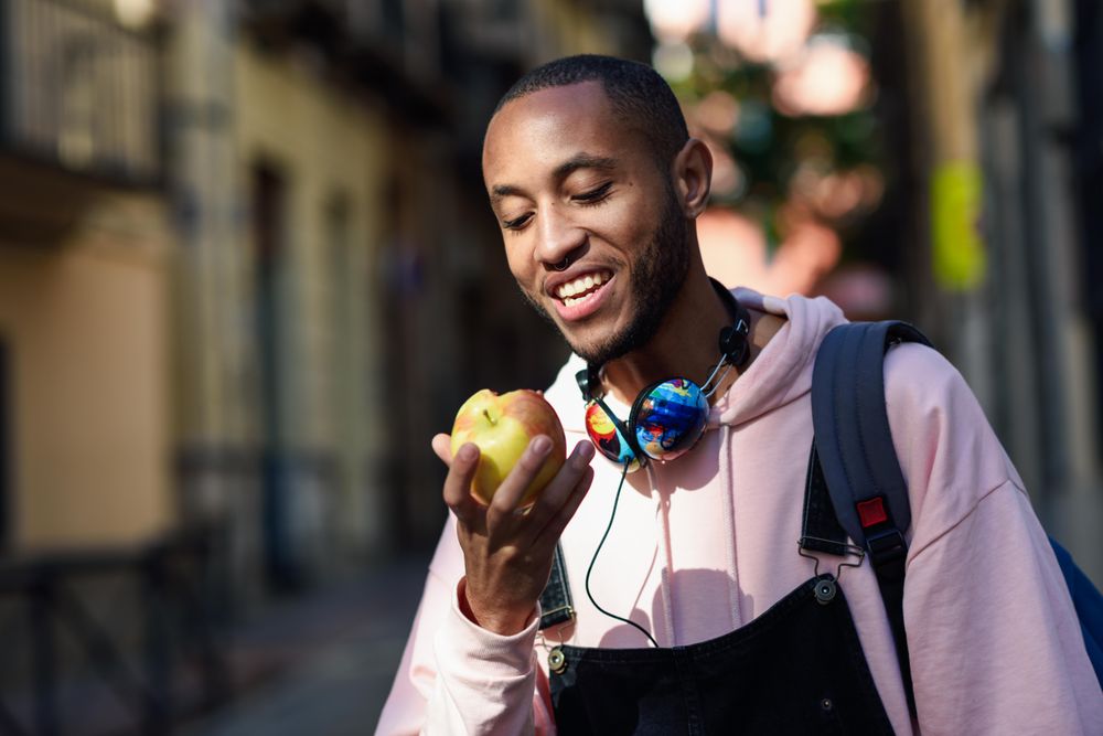 Male on European street eating an apple