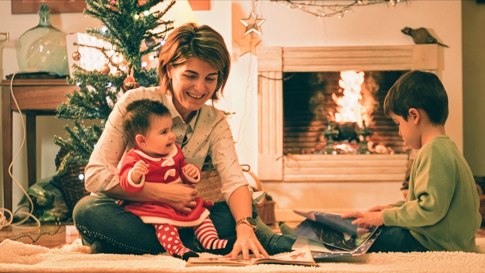 Mother reading book with son on Christmas eve